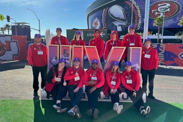 Shenandoah University students pose with the Super Bowl LVIII logo in front of Allegiant Stadium in Las Vegas.